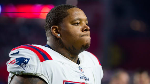 Patriots offensive tackle Trent Brown walks onto the field during a game.